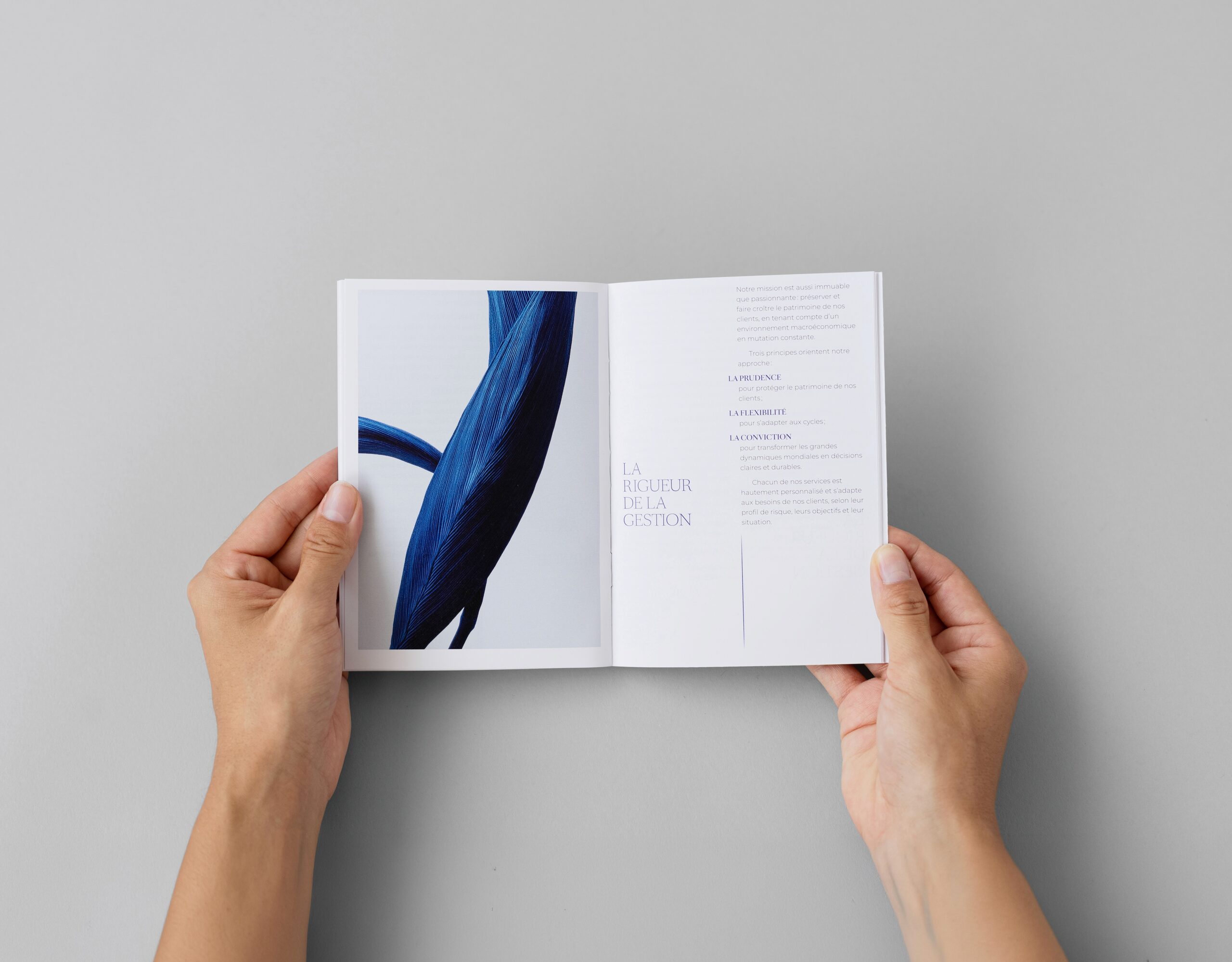 Mains feuilletant un livret Selvi & Cie aux illustrations bleues