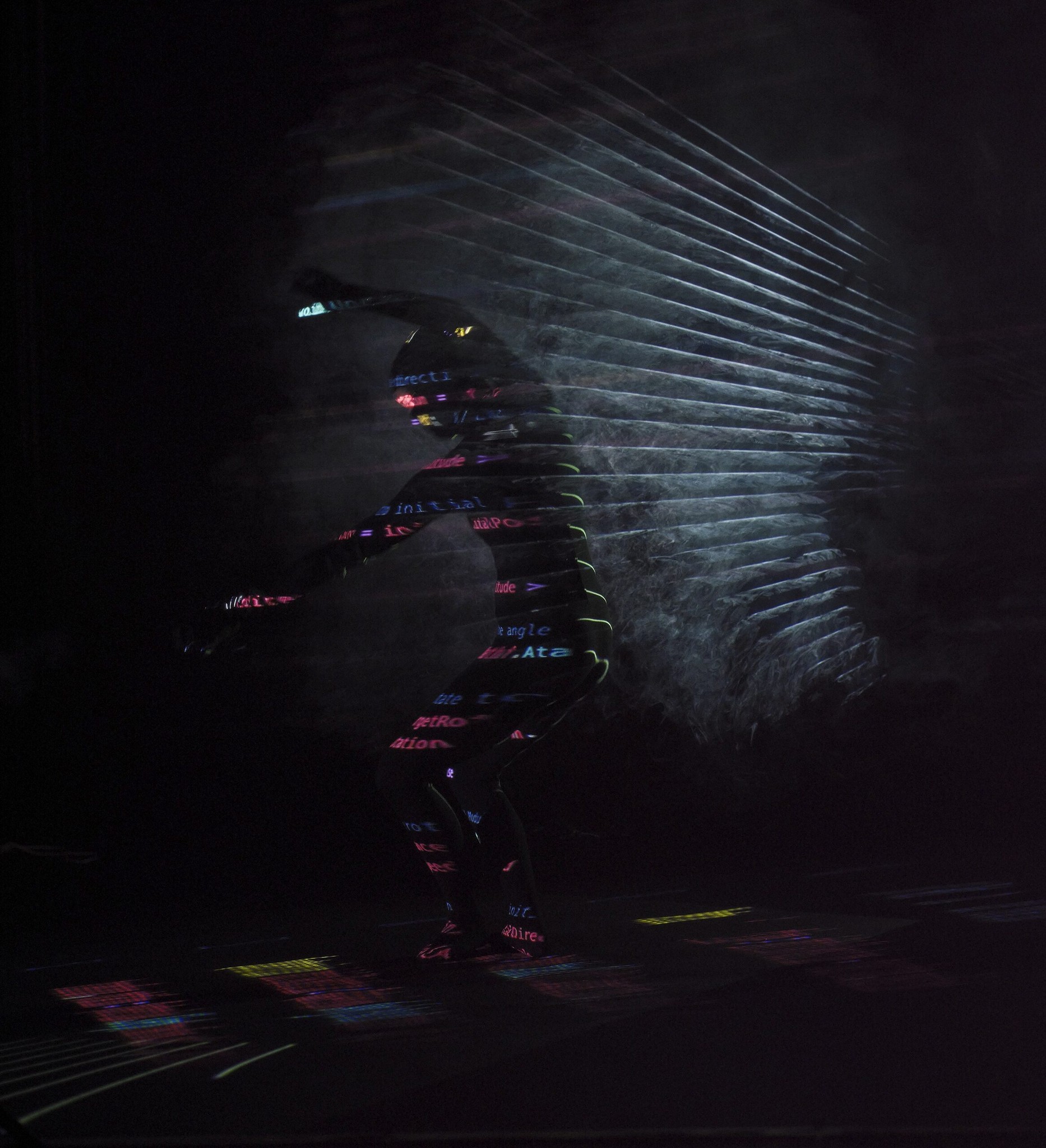 Une danseuse dans l’obscurité, une lumière géométrique projetée sur son corps et sur l’espace derrière elle