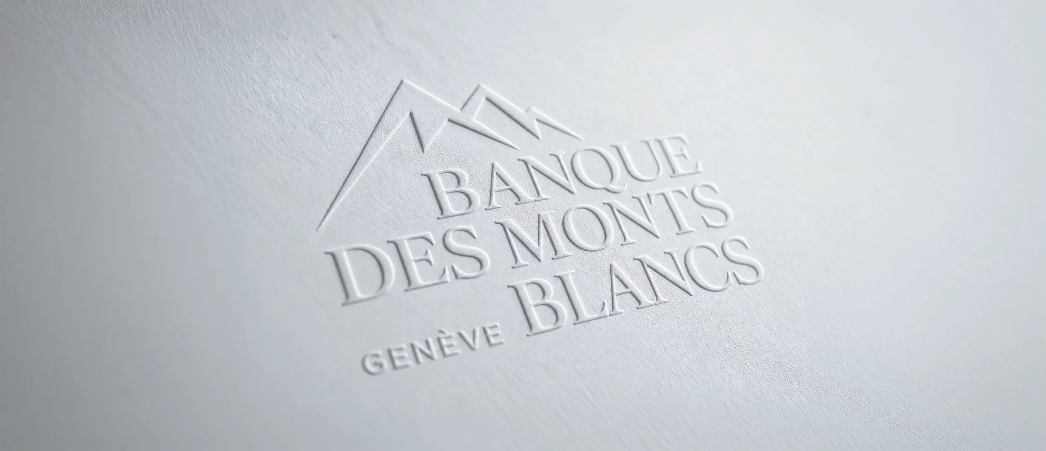 Le logo de la Banque des Monts Blancs gaufré à blanc dans du papier